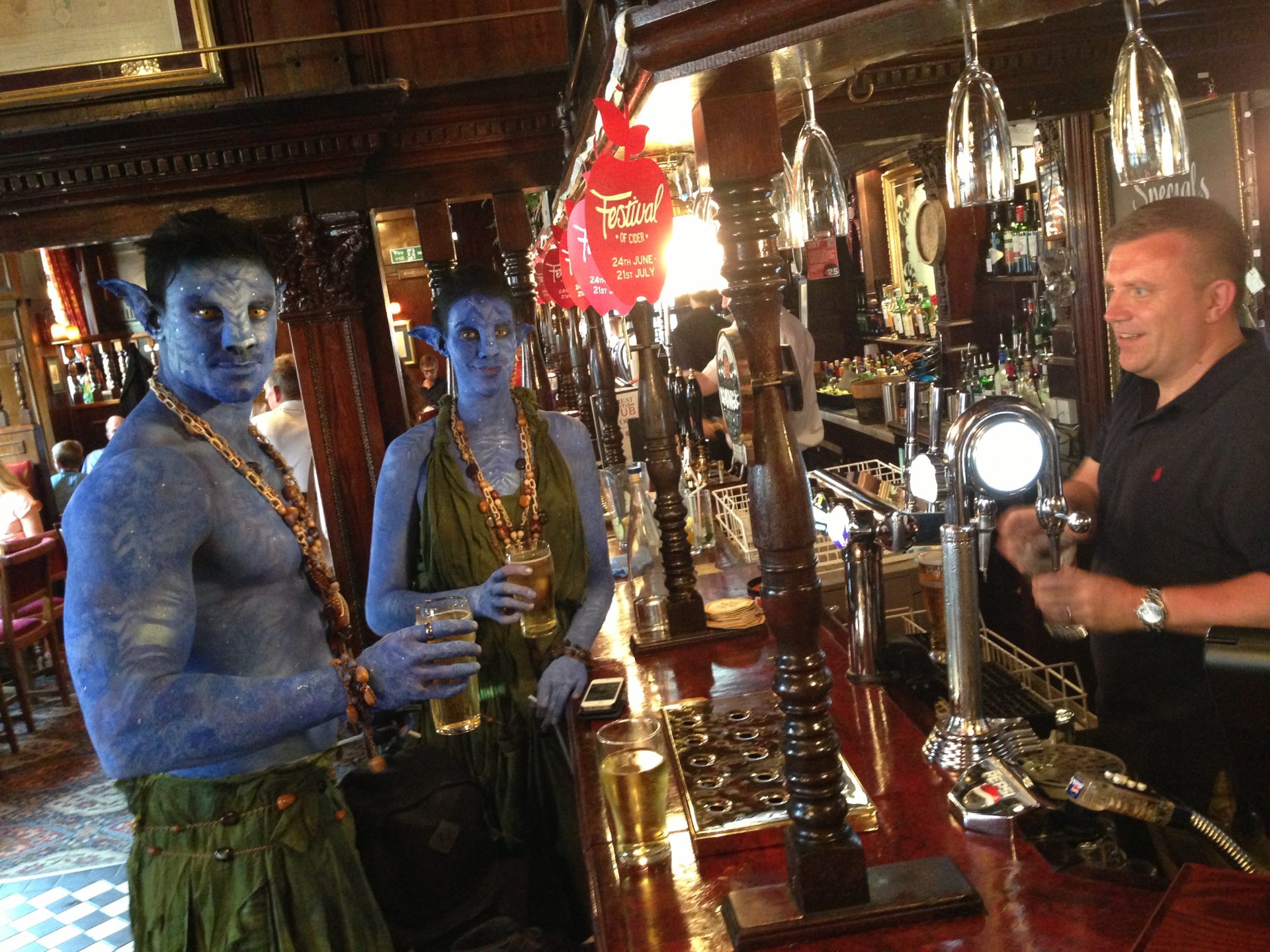 Body painted avatars having a pint in a pub in London male model female model