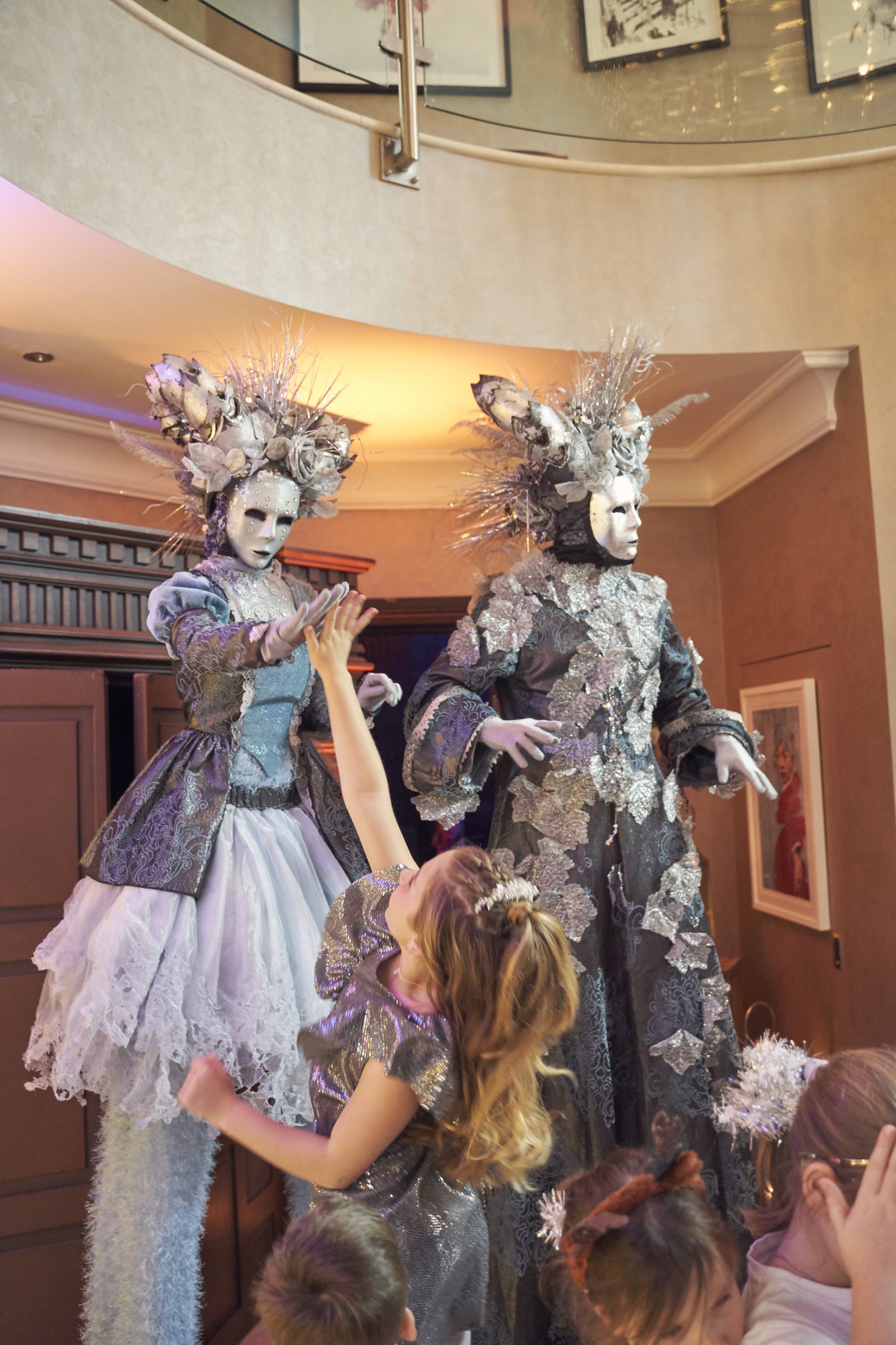 Winter wonderland stilt walker giving a child a high five
