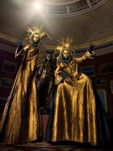 Stilt walkers Venetian masks gold