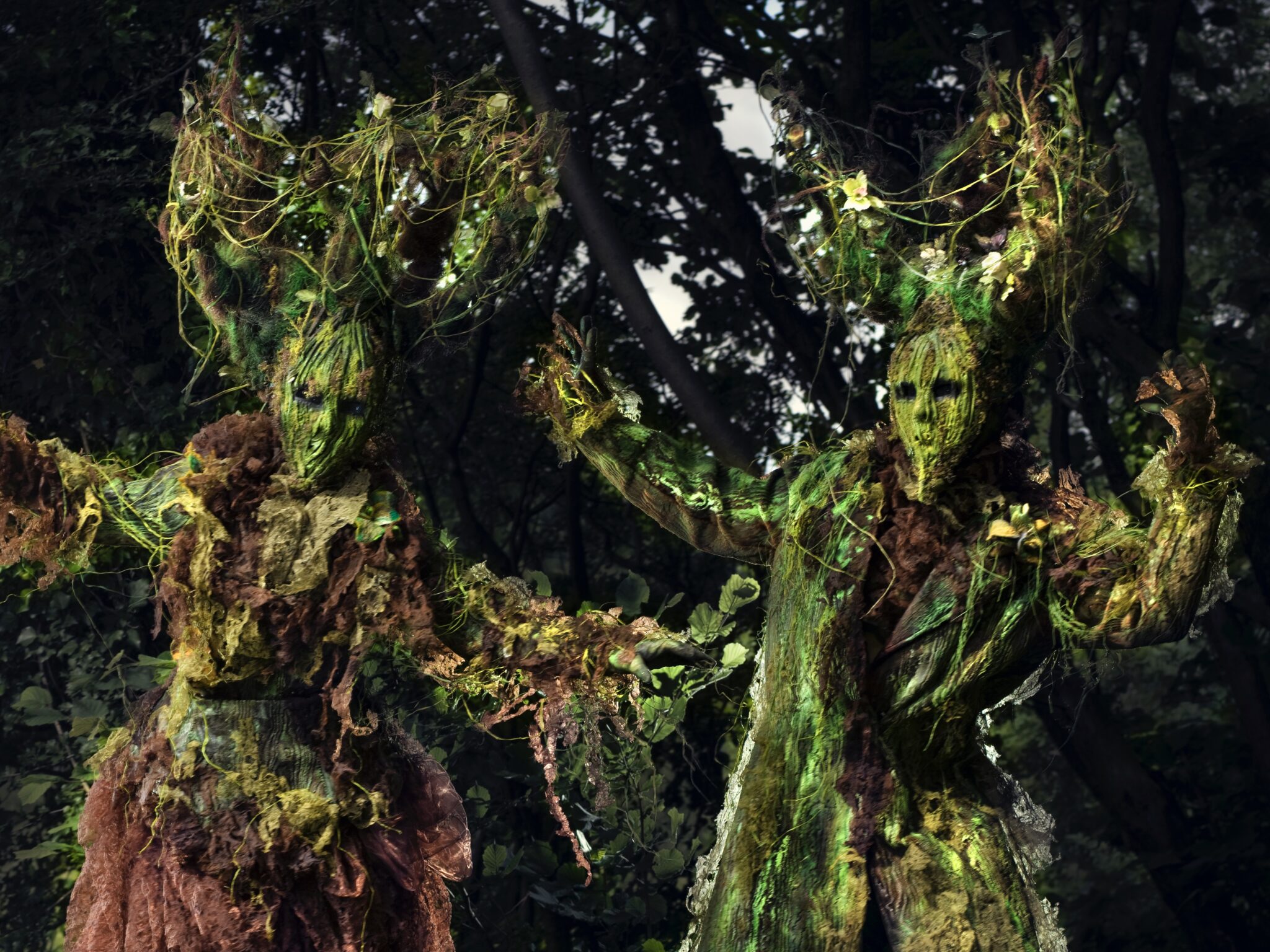 Two stilt walking living tree costumes at an enchanted garden party Two stilt walking living tree costumes at an enchanted garden party