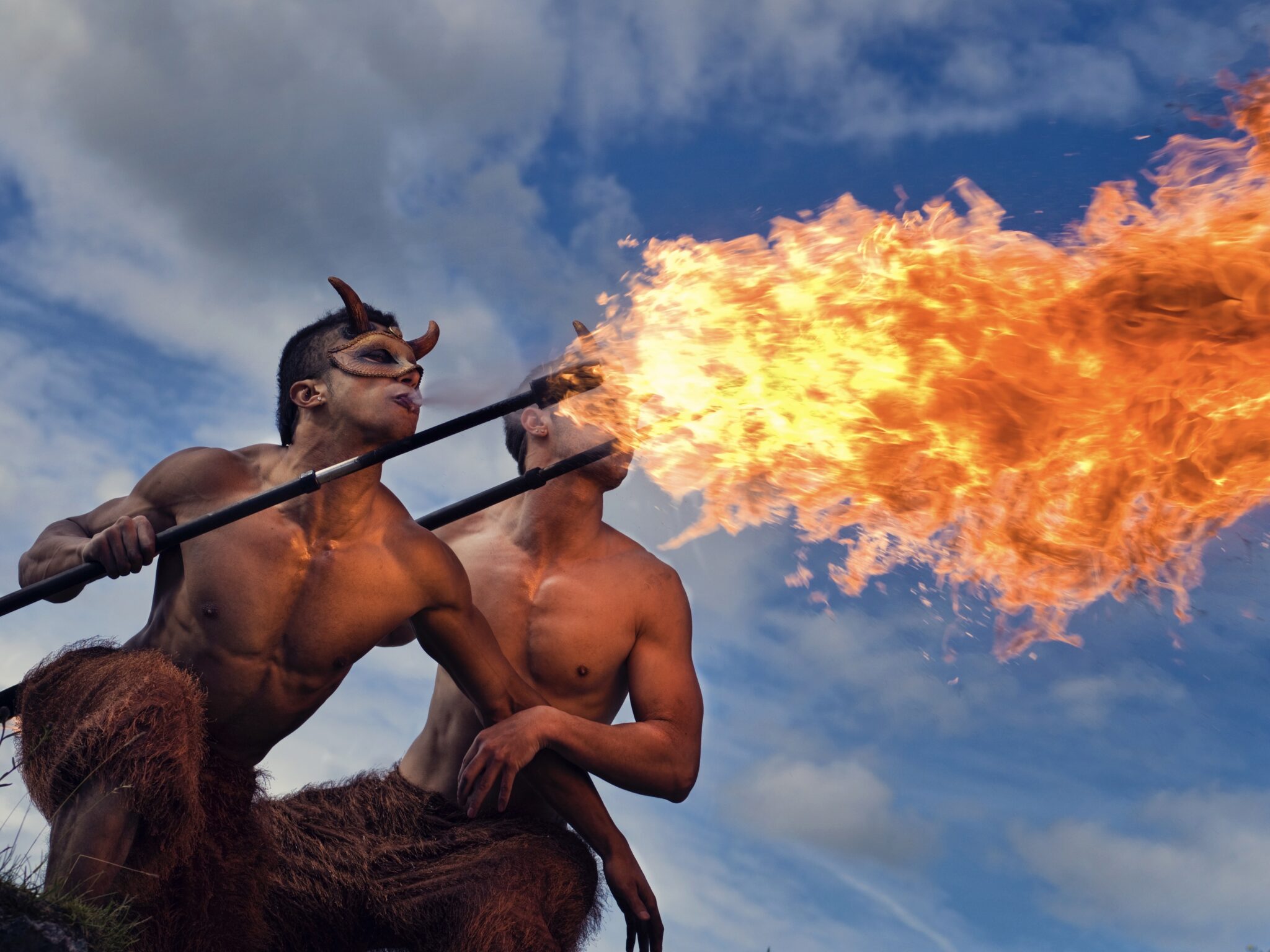 Fire Breathing Pucks Two circus performers dressed as fire breathing pucks. Breathing a large fire cloud from their mouths